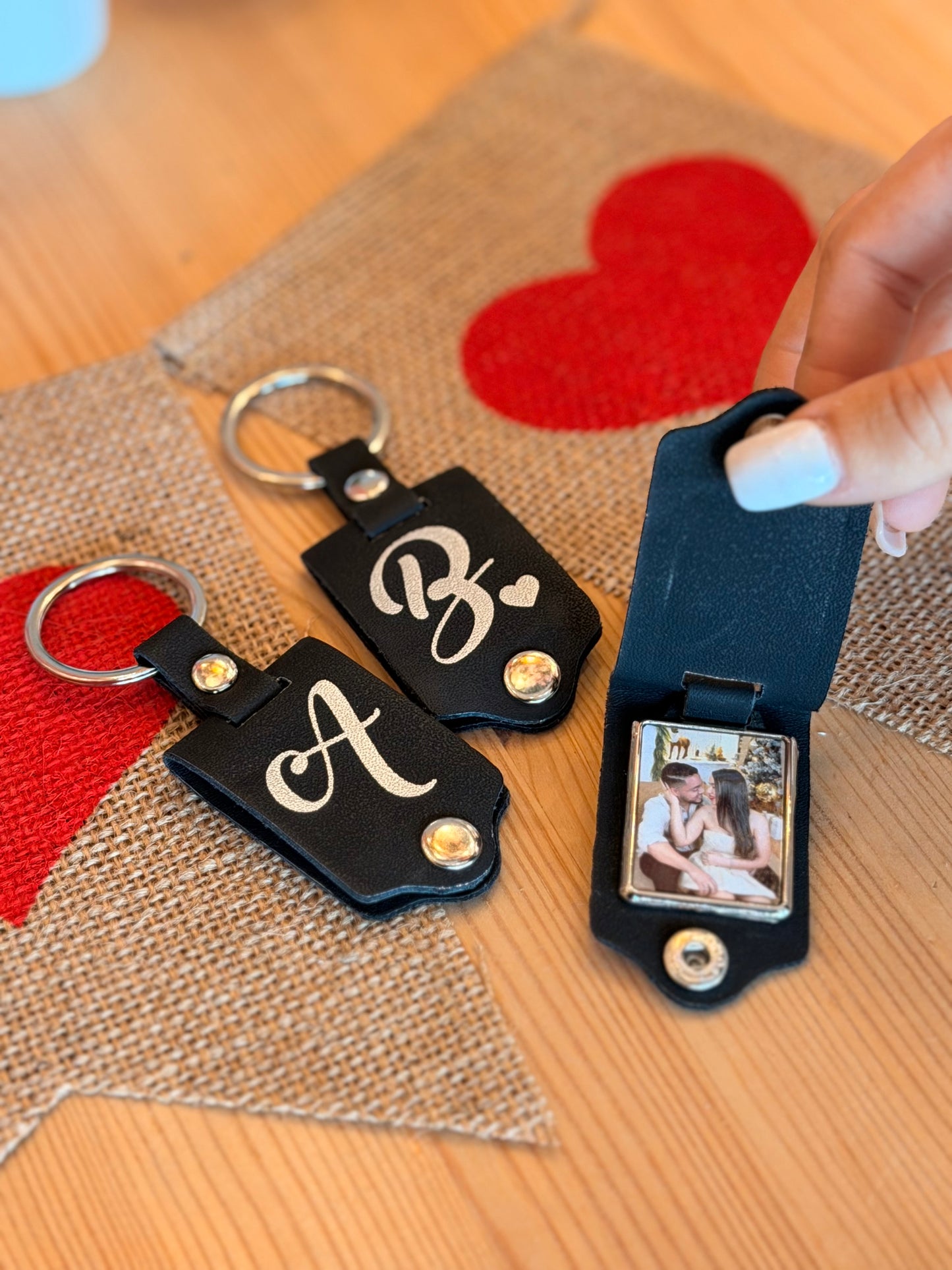 Llavero de piel negra con inicial y foto dentro.